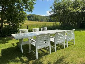 a white picnic table with four white chairs around it at Haqvins stuga in Förslöv