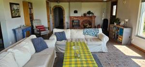 a living room with two white couches and a fireplace at 2 Bedroom Cottage With Spa Accommodations in Glemmingebro