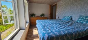 a bedroom with a bed with a blue comforter at 2 Bedroom Cottage With Spa Accommodations in Glemmingebro +5 photos