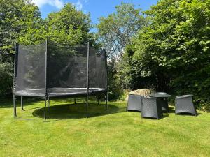 a ping pong net with two chairs and a table at Haqvins stuga in Förslöv