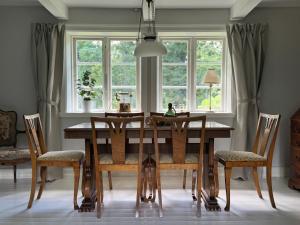 a dining room with a wooden table and chairs at Haqvins stuga in Förslöv +29 photos