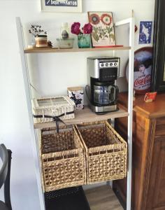 a kitchen shelf with a coffee maker and baskets at Le Stud' à Saint Pierre d'Oléron ! in Saint-Pierre-dʼOléron
