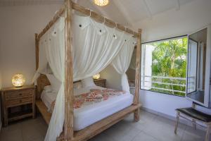 a bedroom with a canopy bed and a window at Majesty Palm Hôtel in Saint-François +131 photos