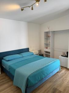 a bedroom with a bed with a blue comforter at B&B Aura in Pontecagnano