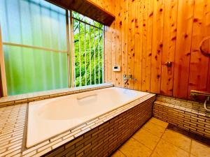 a bath tub in a room with a window at チェックアウトは11時コテージそら豆ん家 in Nasu +51 photos