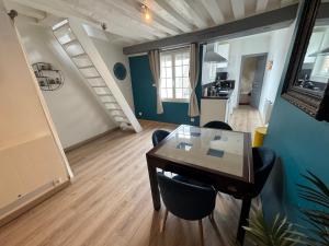 a room with a table and chairs and a staircase at Glycine in Orléans