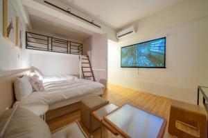 a room with a bed and a tv on a wall at Tainan Little Day in Tainan