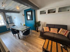 a living room with a couch and a table at Glycine in Orléans +5 photos