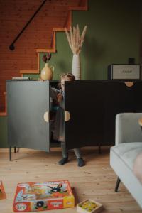 a little girl standing in a cabinet in a living room at Chalúpka na kopcu in Buchlovice