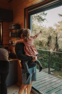 a man holding a little girl looking out of a window at Chalúpka na kopcu in Buchlovice