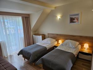 a hotel room with two beds and a window at Piotruś Pan in Niechorze