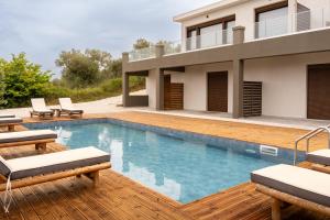 a house with a swimming pool in front of a house at Pnoes Suites Apartments in Skiathos
