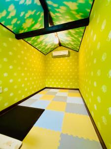 an inside view of a room with yellow walls and a window at チェックアウトは11時コテージそら豆ん家 in Nasu
