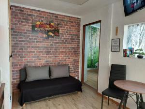 a living room with a couch against a brick wall at Przylesie Dom Turystyczny in Ostróda