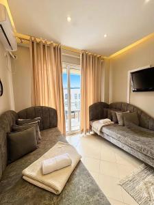 a living room with two couches and a flat screen tv at Solis Apartments in Vlorë