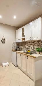 a kitchen with white cabinets and a counter top at Solis Apartments in Vlorë +1 photo