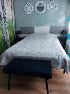 a bedroom with a bed with a gray comforter at Przylesie Dom Turystyczny in Ostróda