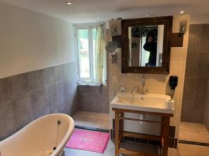 a bathroom with a tub and a sink and a mirror at labalade chambre pelerin in Marsac