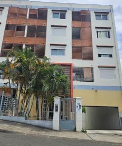 an apartment building with palm trees in front of it at L'Interlude in Saint-Denis