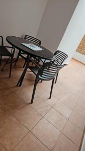 a black table and chairs sitting on a tile floor at L'Interlude in Saint-Denis