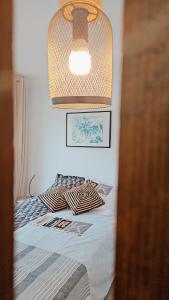 a bedroom with a bed with a light above it at L'Interlude in Saint-Denis
