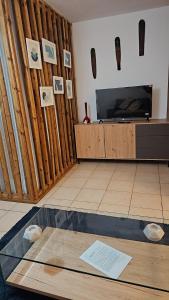 a living room with a tv and a table at L'Interlude in Saint-Denis