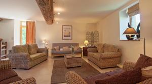 a living room with chairs and a couch and a table at Moulin de Limayrac in Colombiès