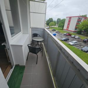 a balcony with a table and a chair on it at Apartmán Grand in Partizánske