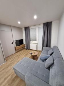 a living room with a blue couch and a table at Apartmán Grand in Partizánske