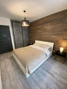 a bedroom with a bed and a wooden wall at Apartament AquaTower, Aquapark Reda in Reda +11 photos