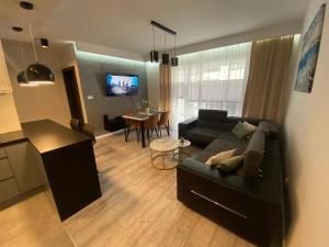 a living room with a couch and a dining room at Apartament AquaTower, Aquapark Reda in Reda