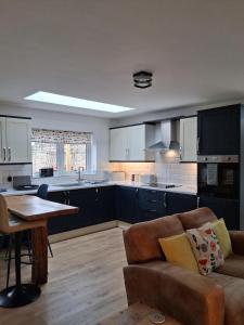 a kitchen with a couch and a table in a room at Secret Bungalow in Warsop
