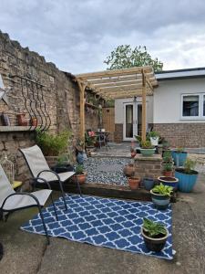 a patio with chairs and a blue and white rug at Secret Bungalow in Warsop