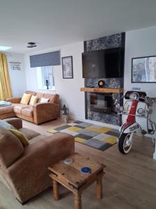 a living room with a scooter in front of a fireplace at Secret Bungalow in Warsop