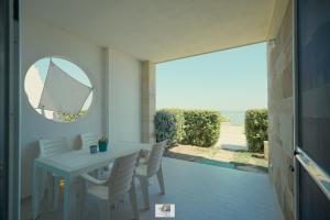 ein Esszimmer mit Tisch, Stühlen und Spiegel in der Unterkunft Dimore di Mare in Termoli