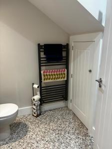 a bathroom with a toilet and a towel rack at Blackhill Lookout in Portrush +17 photos