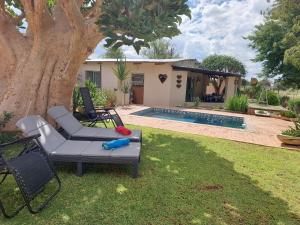 a backyard with a pool and a house with a tree at Orpheus Camping in Kaneb Pos