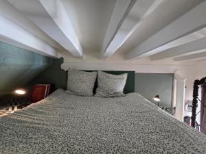 a large bed in a room with a ceiling at Escale in Beauvais