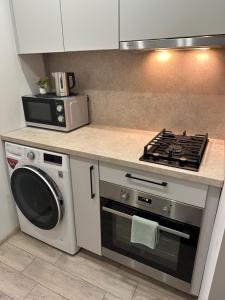 a kitchen with a stove and a washing machine at Studio between two stations in Šiauliai