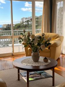 a living room with a vase of flowers on a table at Bluegreen in Arco da Calheta +33 photos