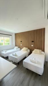 a room with three beds and a window at El Chalecito De Alicante in El Campello