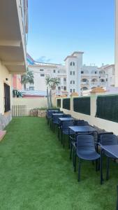 a row of tables and chairs on the balcony of a building at El Chalecito De Alicante in El Campello