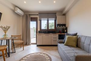 a living room with a couch and a table at Pnoes Suites Apartments in Skiathos