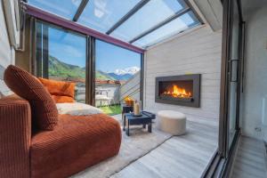 eine überdachte Veranda mit Kamin und Sofa in der Unterkunft Nid face au MontBlanc - 55m2 de charme in Sallanches