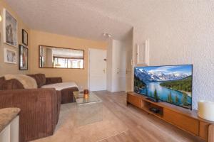 ein Wohnzimmer mit einem großen Flachbildfernseher in der Unterkunft Nid face au MontBlanc - 55m2 de charme in Sallanches
