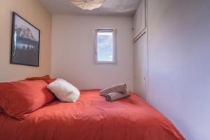 ein rotes Bett in einem Zimmer mit Fenster in der Unterkunft Nid face au MontBlanc - 55m2 de charme in Sallanches
