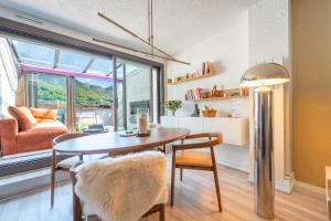 ein Esszimmer mit Tisch und Stühlen und einem Fenster in der Unterkunft Nid face au MontBlanc - 55m2 de charme in Sallanches