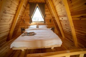 a bed in a log cabin with a window at Hedwig cottages 2 in Žabljak