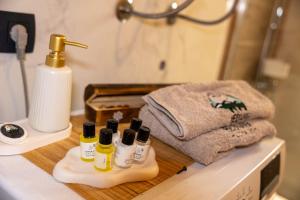 a bathroom counter with four bottles of soap and towels at Hedwig cottages 2 in Žabljak +26 photos