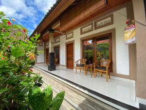 a balcony of a house with a table and chairs at Raka Rai House in Ubud